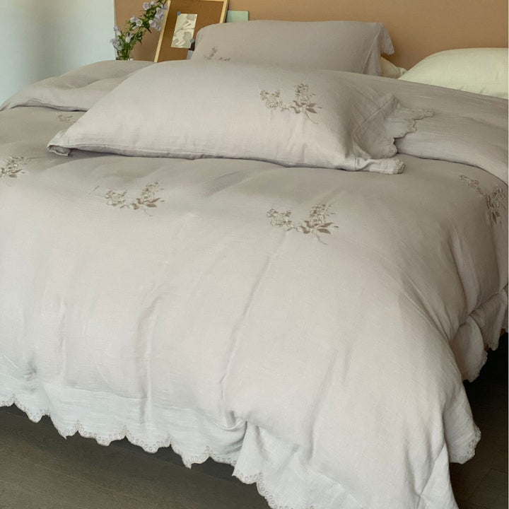 Linen look bedding set with floral embroidery and wavy hem