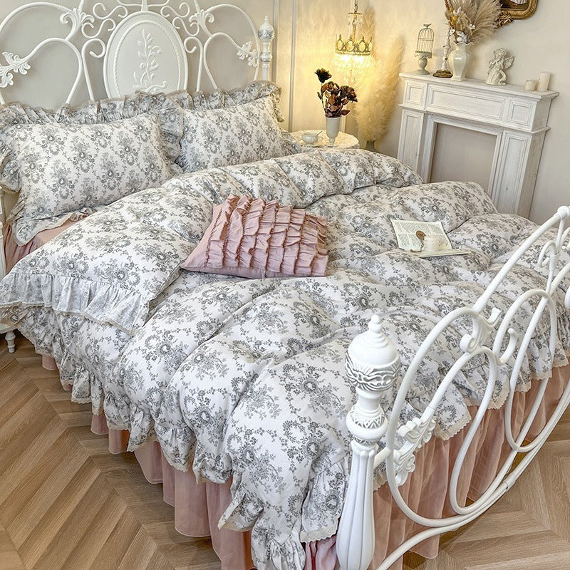 Romantic quilted comforter with ruffled border and fine floral pattern