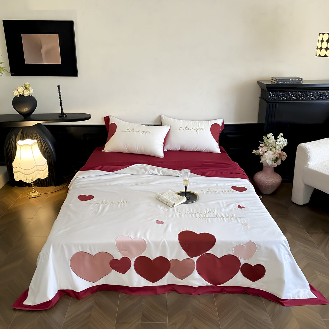 Bedding set with quilted heart appliqués and satin border