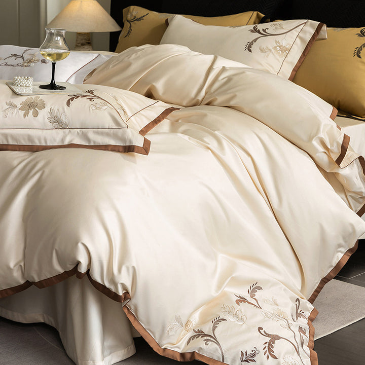 Luxurious embroidered satin bed linen set with floral corner motif and contrast piping