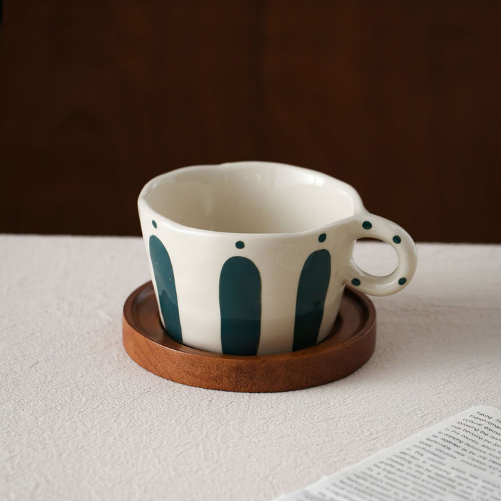 Ceramic espresso cup with round wooden coaster and handcrafted stripe pattern