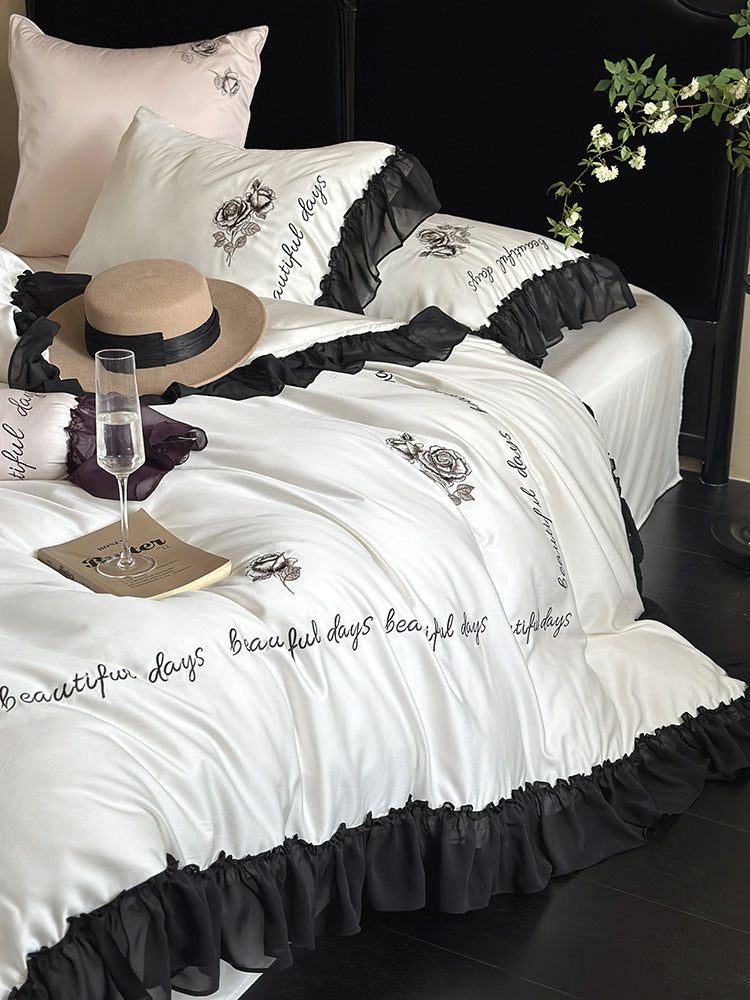 Bedding set made of silky-soft cotton satin with ruffle, delicate rose embroidery, and decorative lettering