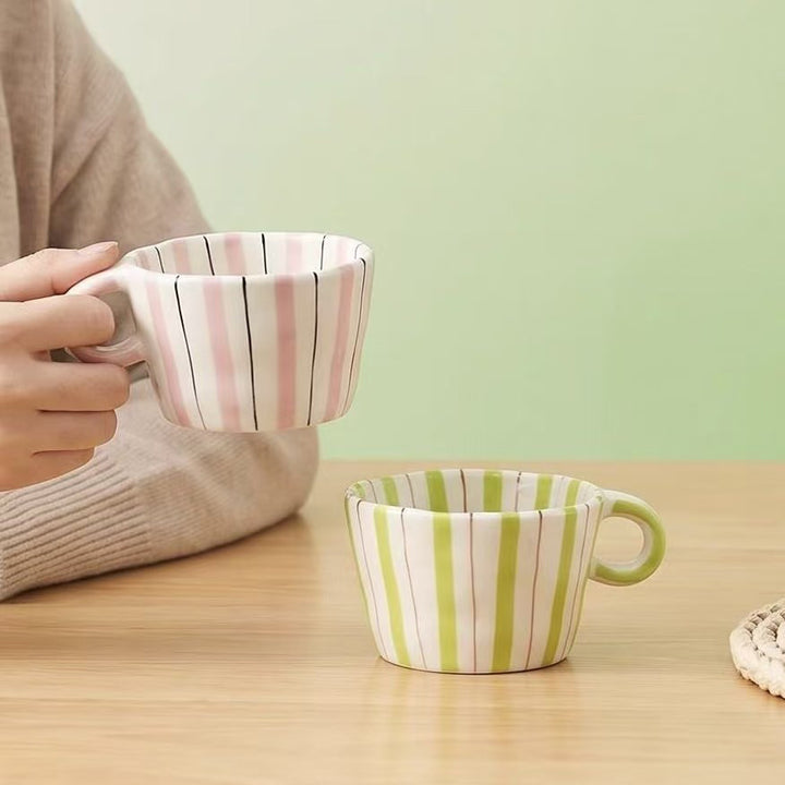 Ceramic coffee mug with ergonomic round handle and fine striped texture