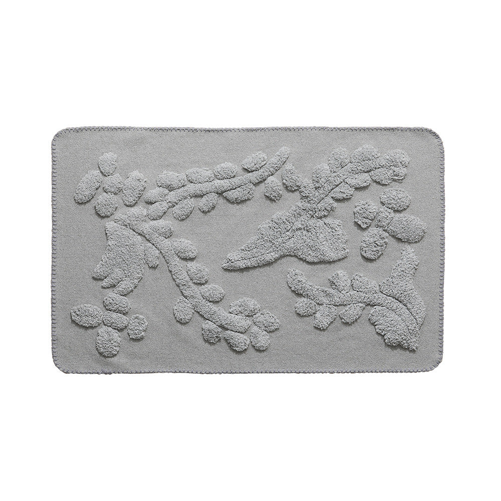 Rectangular cotton bath mat with abstract 3D tuft relief and non-slip back