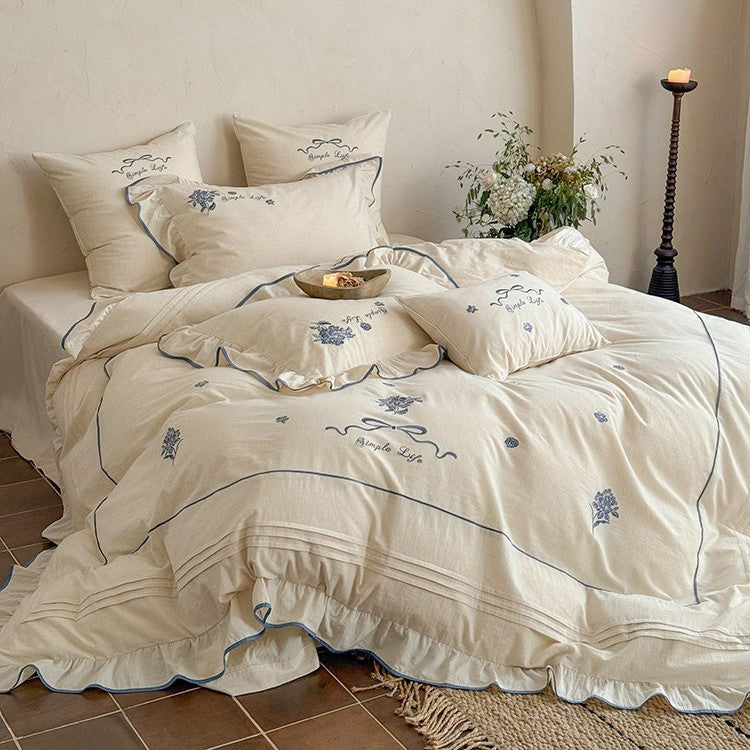 Cotton muslin bedding set with delicate floral embroidery, ruffle, and breathable finish