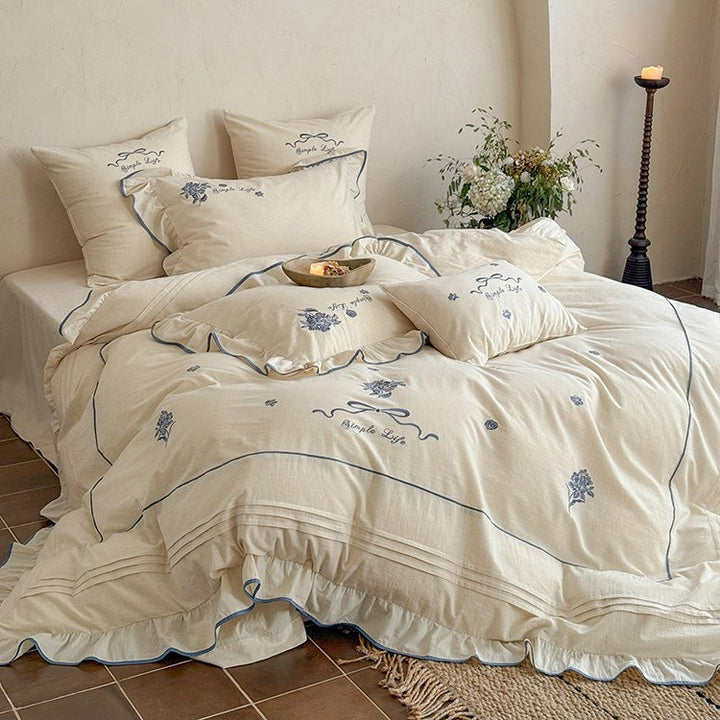 Cotton muslin bedding set with delicate floral embroidery, ruffle, and breathable finish