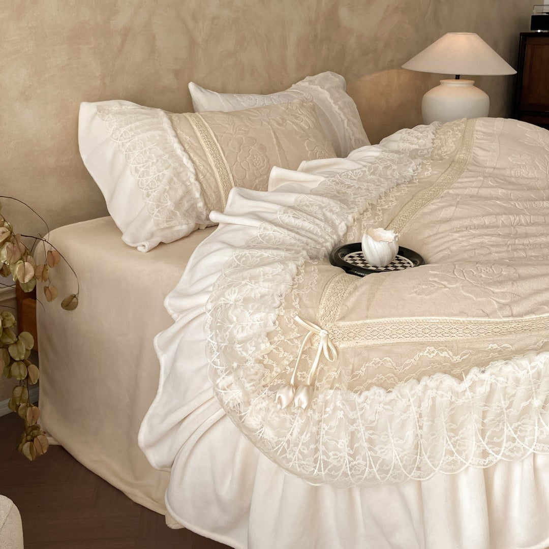 Luxury bedding set with quilted coverlet, lace ruffle, and decorative bed skirt