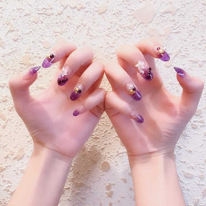 Artistic Press-On Nail Design with Glitter and Floral Accents