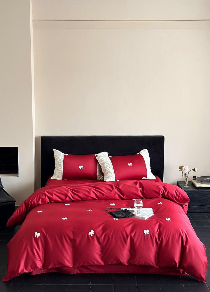 Luxurious cotton satin bedding set with embroidered bows and ruffle details