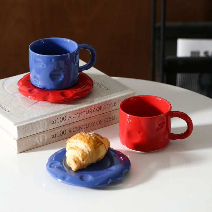 Ceramic coffee cup set with textured relief surface and wavy saucer