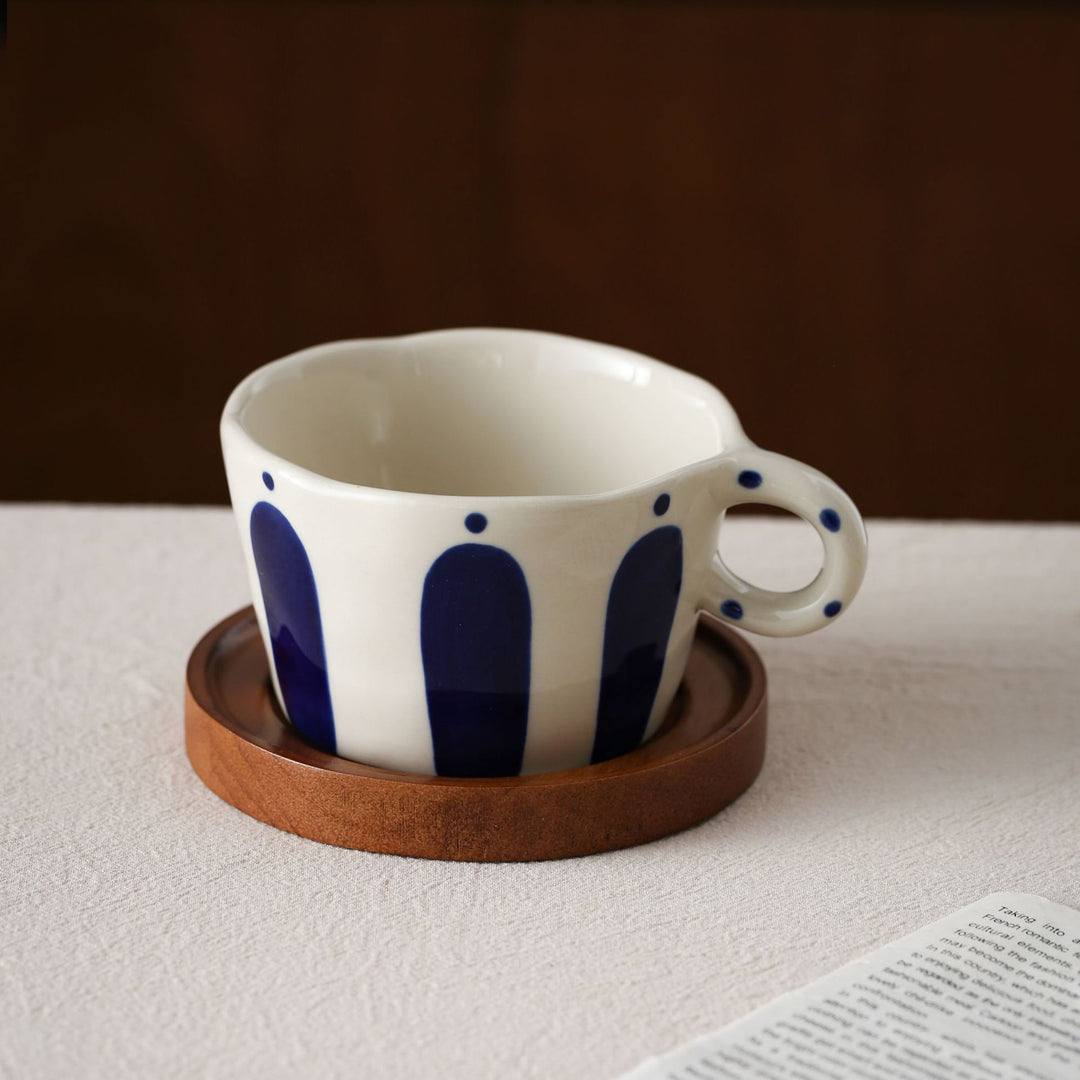 Ceramic espresso cup with round wooden coaster and handcrafted stripe pattern