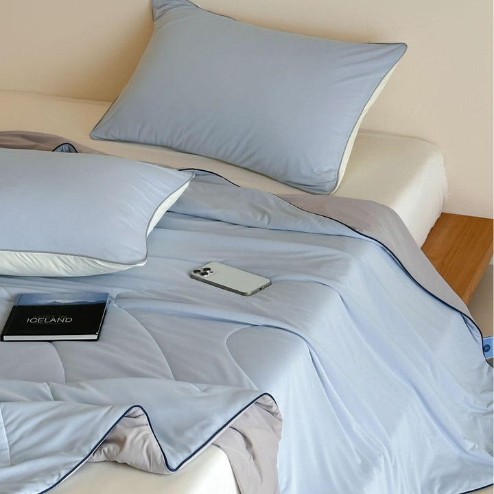 Elegant bedding set made of cotton satin with contrasting piping and light quilted blanket