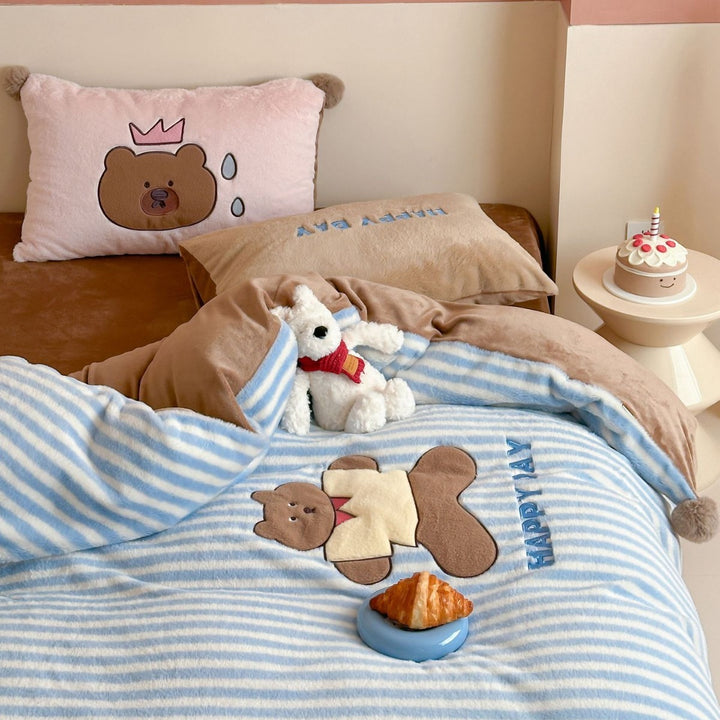 Striped plush throw blanket with decorative pom poms and appliqués