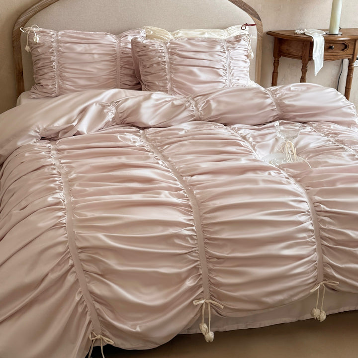 Satin bedding set with gathered drawstring look and tassels