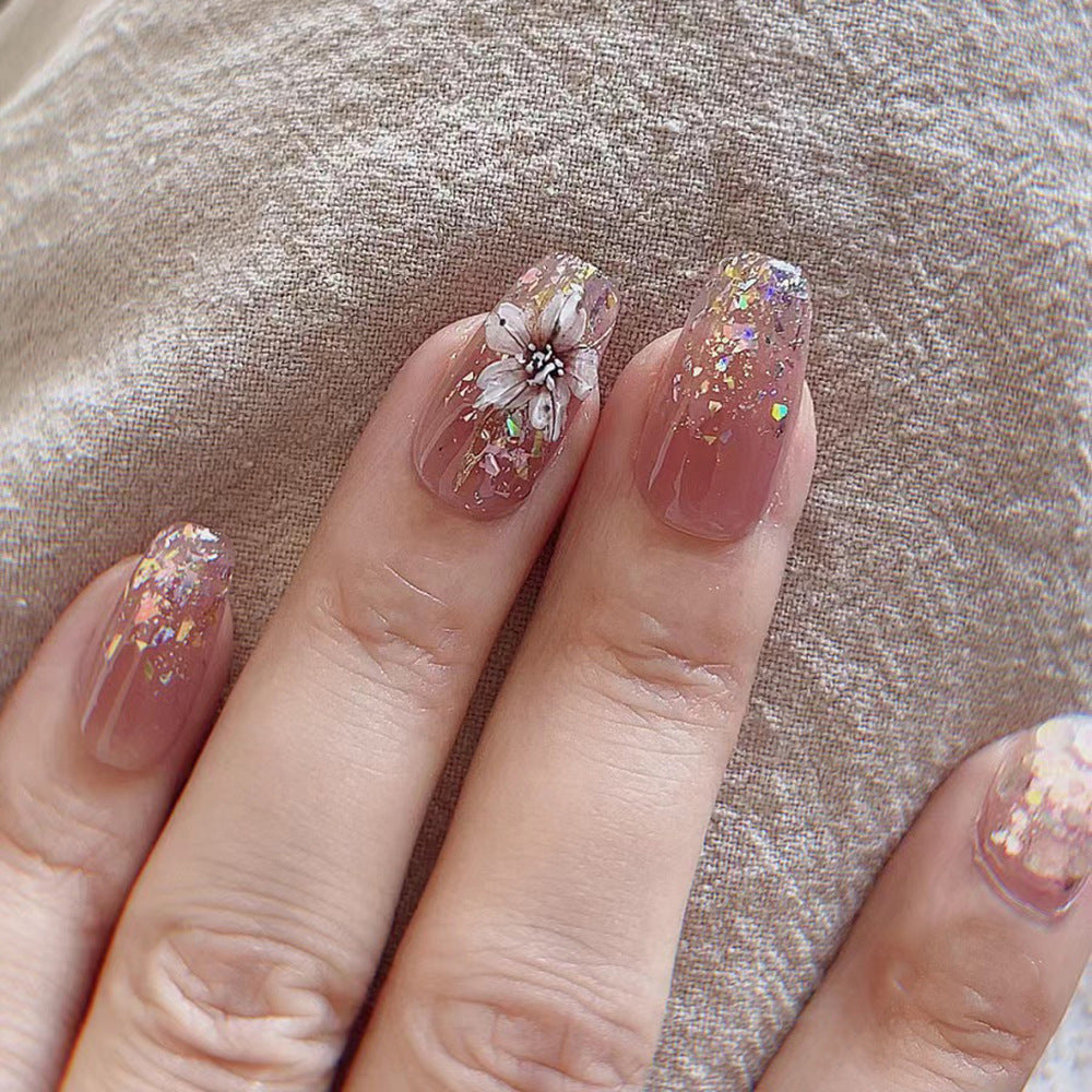 Artificial nail extensions with floral design and glitter accents Kalsten