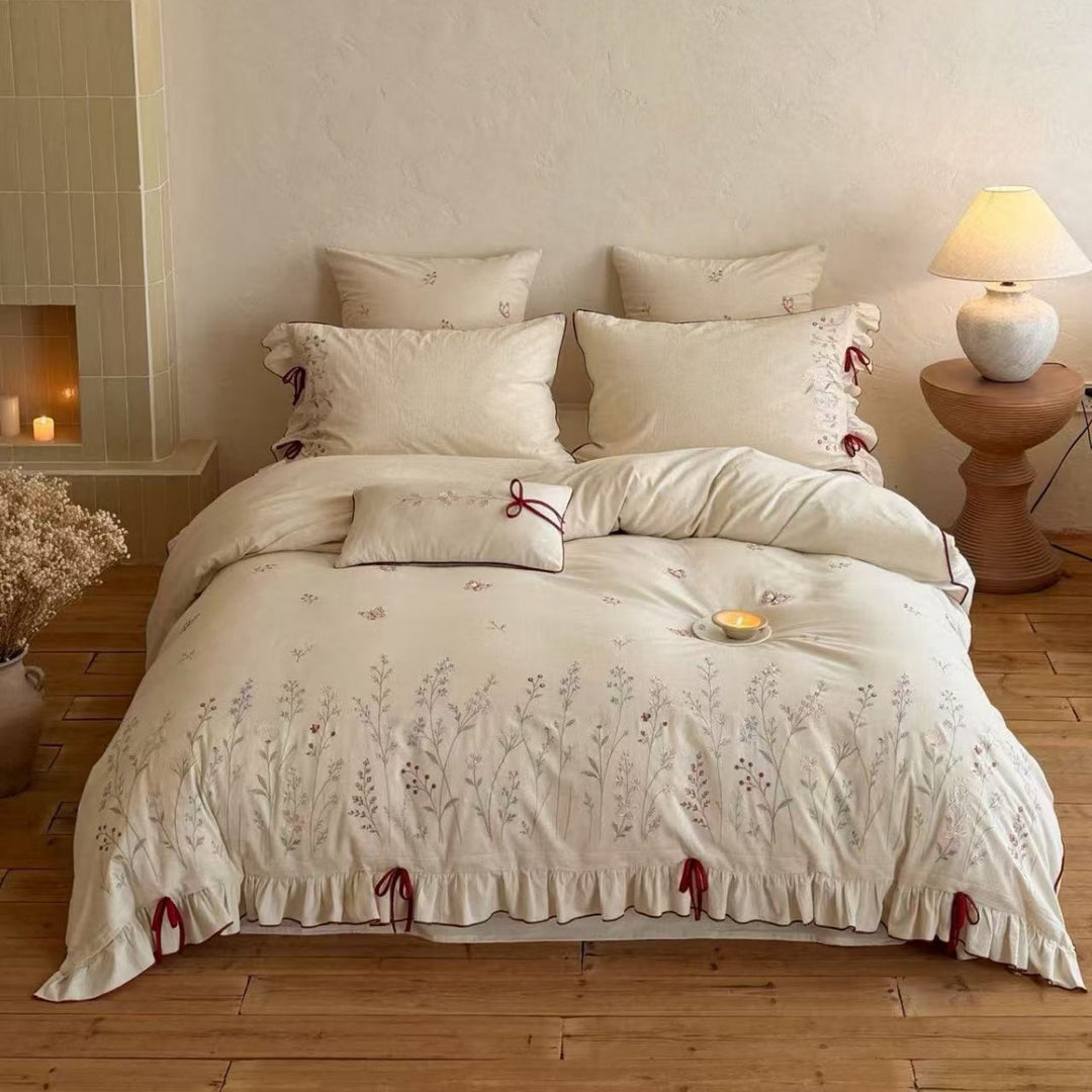 Natural fiber duvet cover set with delicate floral hand embroidery, linen look, and decorative ruffle