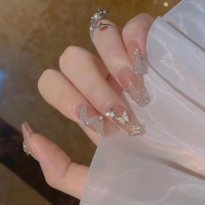 Glamorous nail art with rhinestone and butterfly elements Kalsten