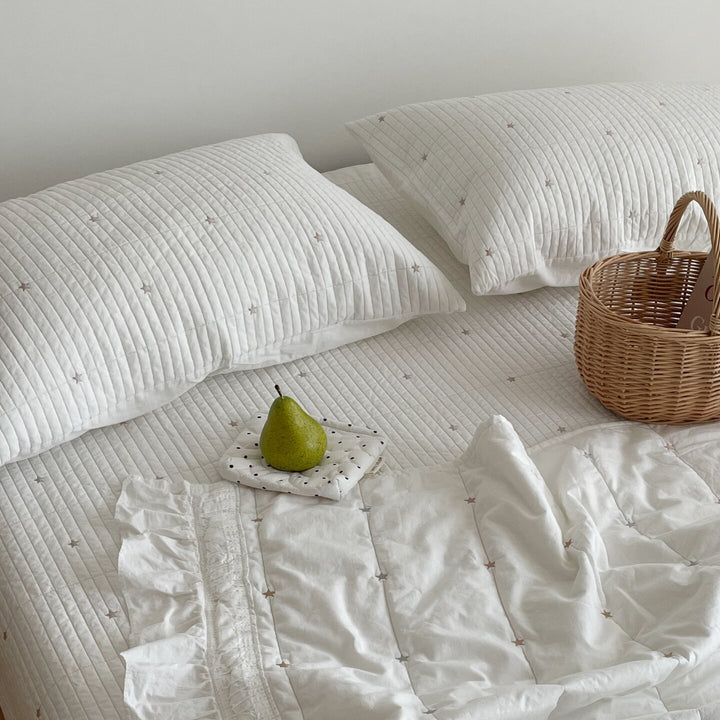 Quilted bedspread with delicate longitudinal stitching and matching pillowcases