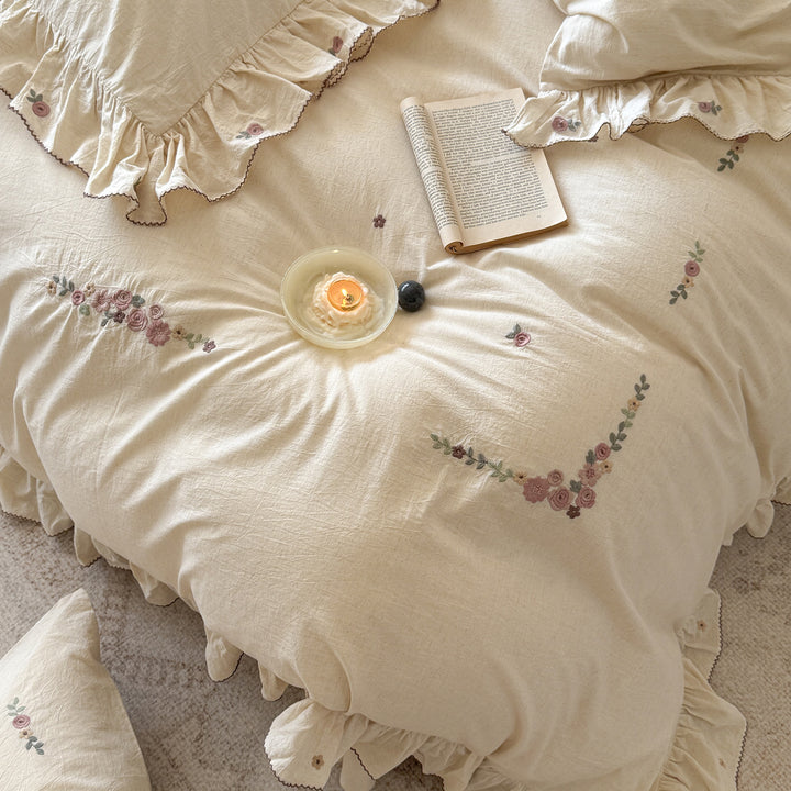Bedding set in natural linen style with delicate rose garland embroidery and ruffled trim