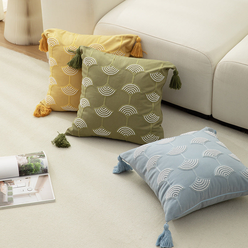 Square decorative pillow with embroidered fan motif and decorative tassels