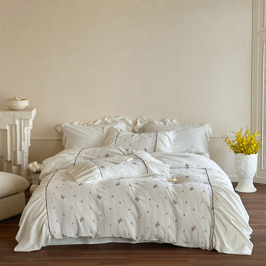 Cotton muslin bedding set with embroidered striped relief, gathered ruffle and fine piping