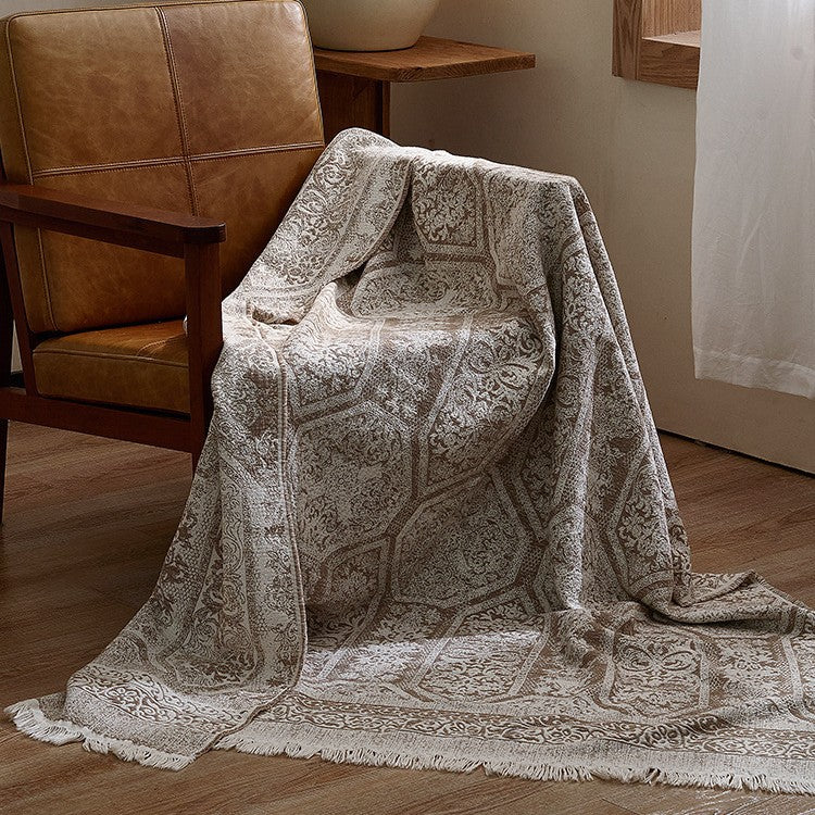 Large cozy living blanket made of cotton blend fabric with geometric jacquard pattern and fringed hem