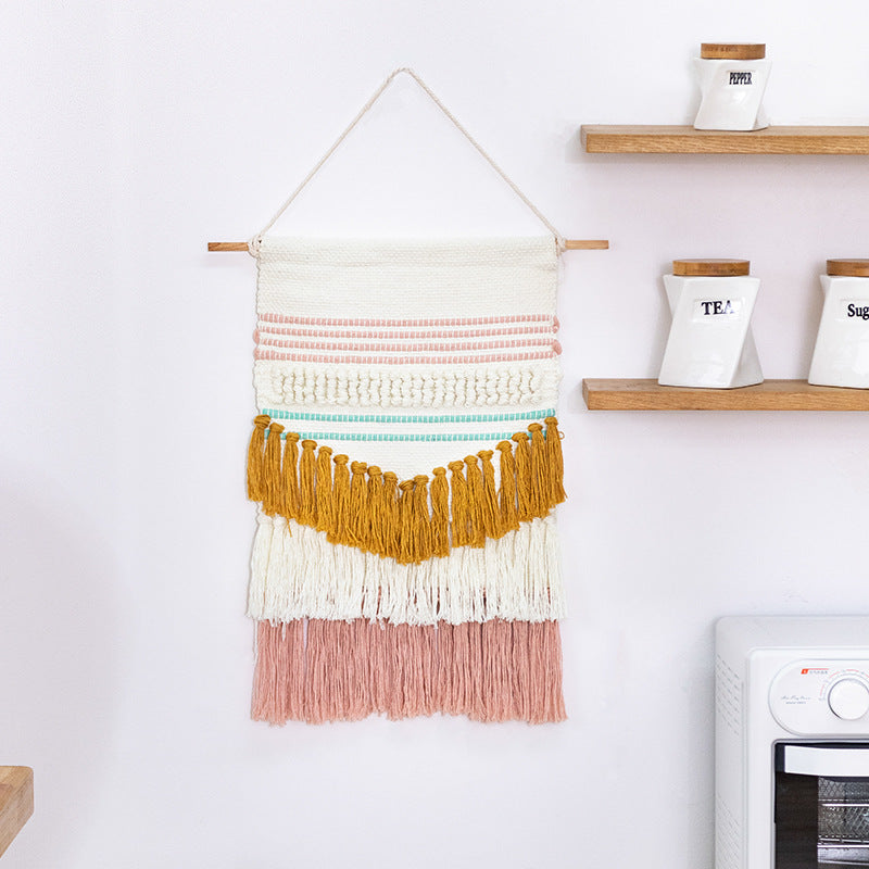 Handwoven wall hanging in boho style with tassels and geometric structure