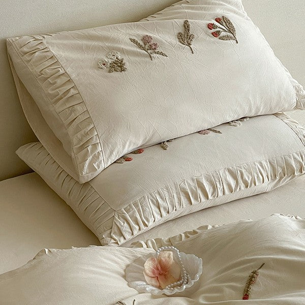 Cotton bedding set with delicate floral embroidery and ruffled edge