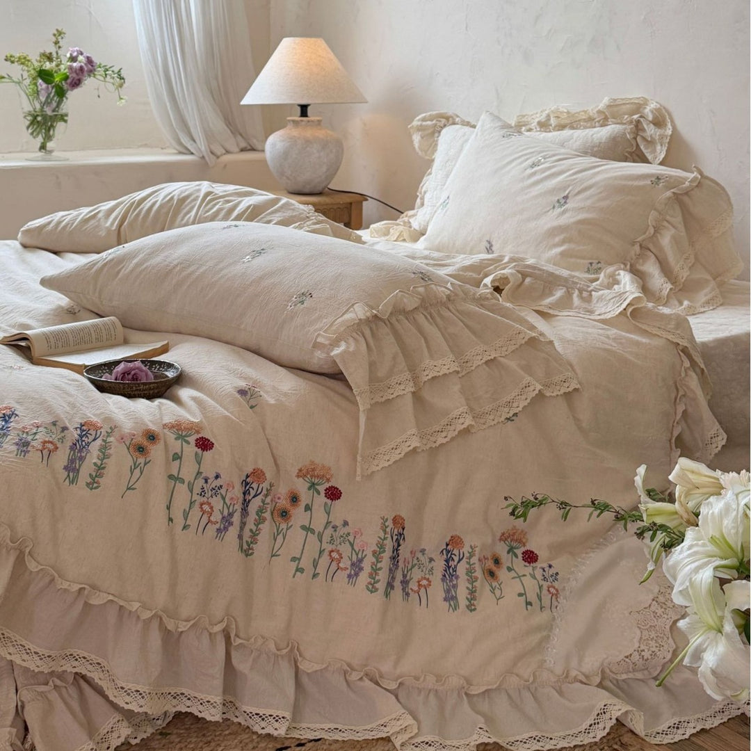Romantic linen-cotton bedding set with embroidered floral border and ruffle