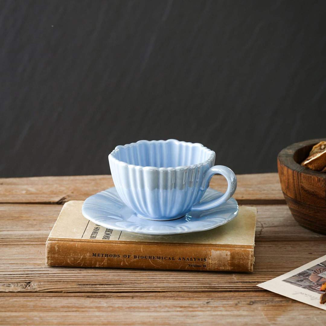 Fine porcelain tea cup with ribbed shell shape and matching saucer
