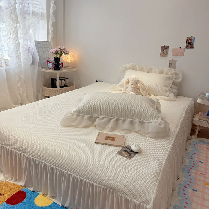 Quilted bedspread with ruffle and delicate floral quilting