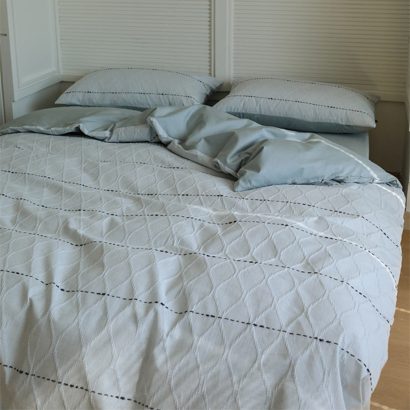 Reversible quilted bedding set made of cotton blend with textured leaf quilting and satin finish back