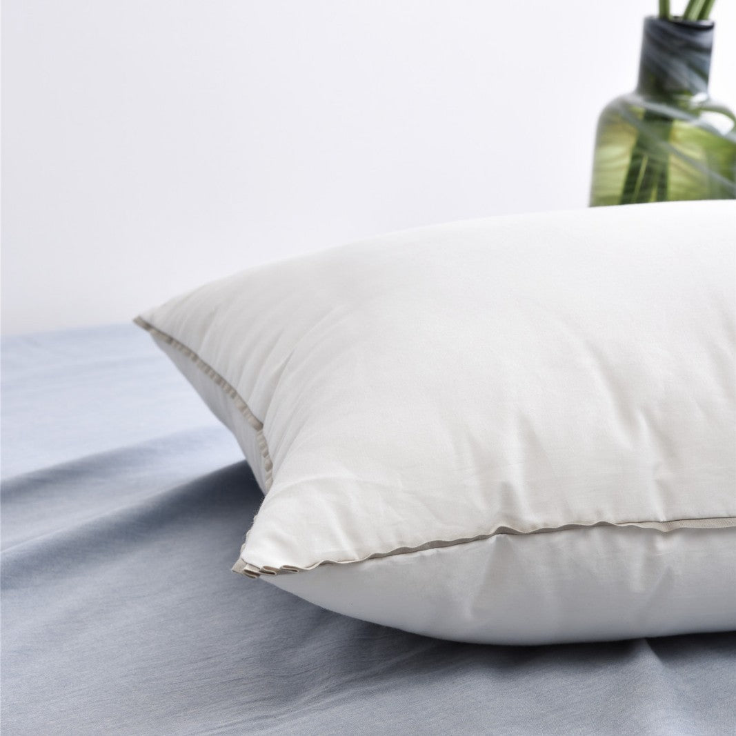 Comfort pillow with shape-stable hollow fiber filling and contrasting piping