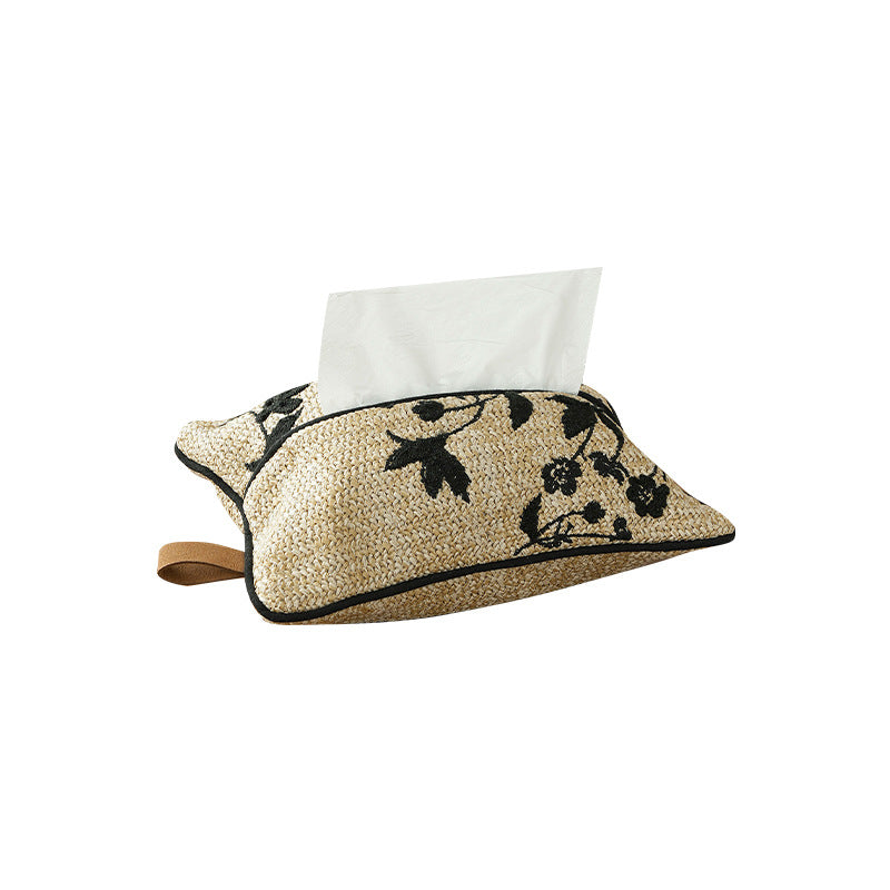 Woven tissue box cover made of straw with embroidered floral design and carrying strap