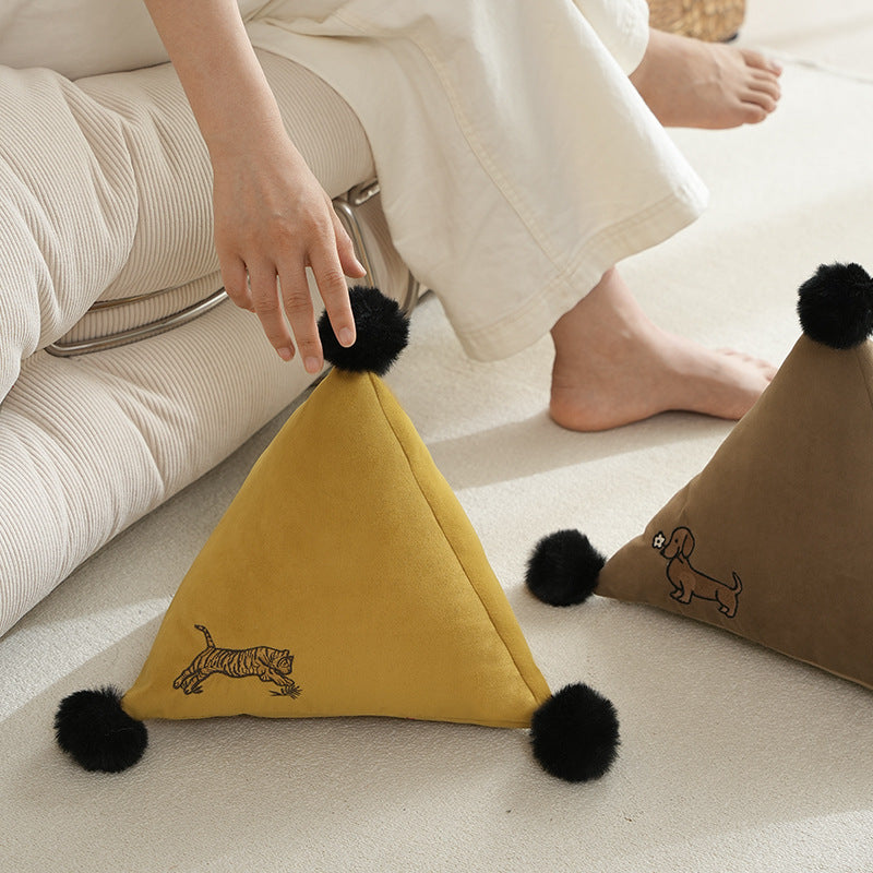 Pyramid-shaped triangle cushion with faux fur pom-poms and zebra embroidery