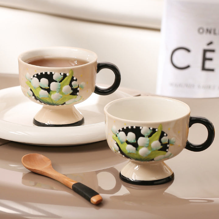 Ceramic foot cup with hand-painted lily of the valley relief and round handle