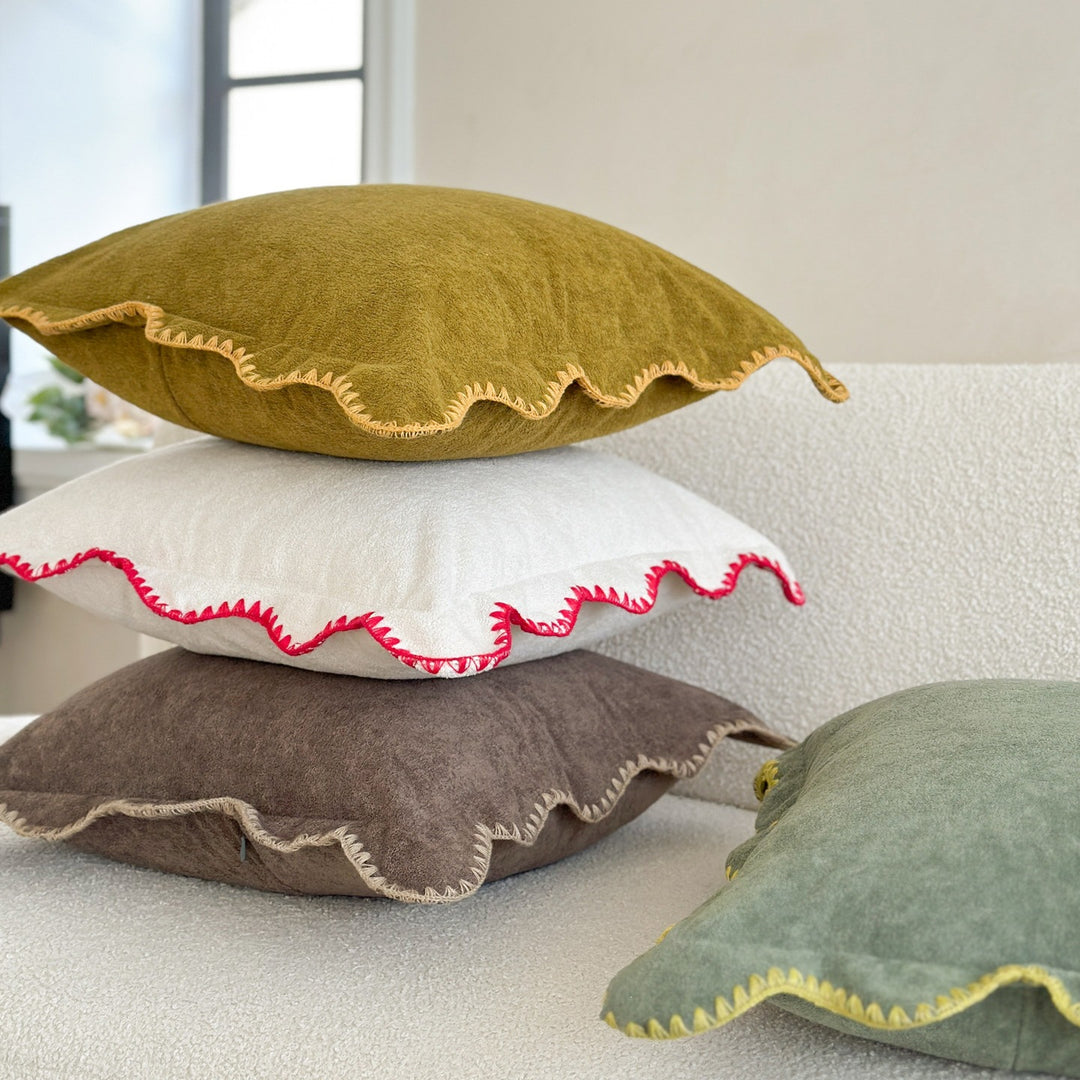 Decorative velvet cushion with wavy edge and decorative stitching