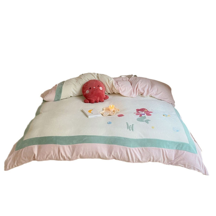 Cozy bedding set with plush border, embroidered appliqués, and reversible function