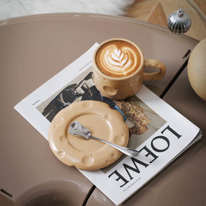Sculptural ceramic cup set with flowing glaze and textured saucer
