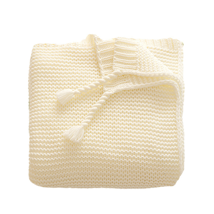Chunky knitted cozy blanket with diamond pattern and colorful knots