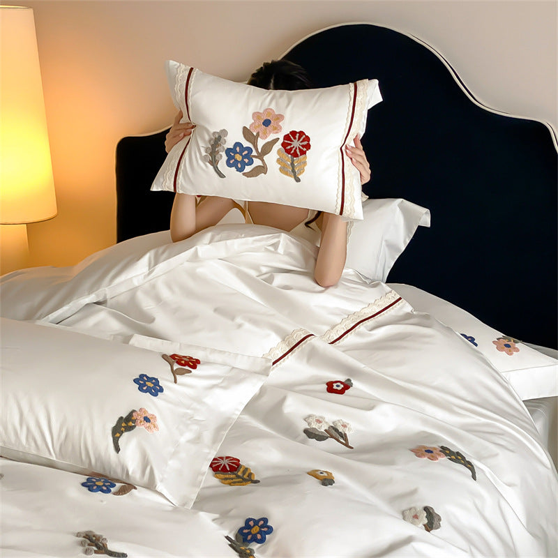 Embroidered cotton satin bedding set with floral applications and decorative border
