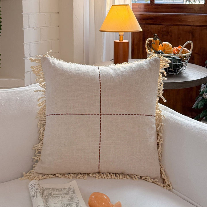 Decorative cushion made of linen look with hand-tied fringes and cross-stitch detail