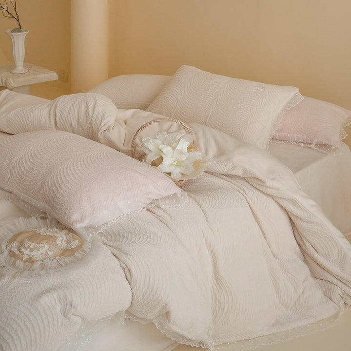 Quilted bedding set with lace edge and wave quilting pattern