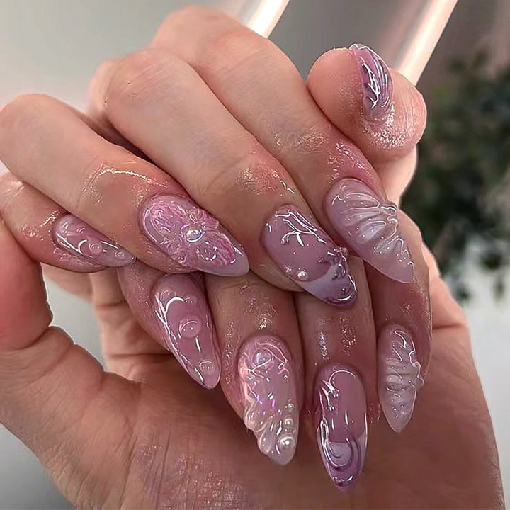 Artificial nail extensions with delicate floral designs and glitter accents Kalsten
