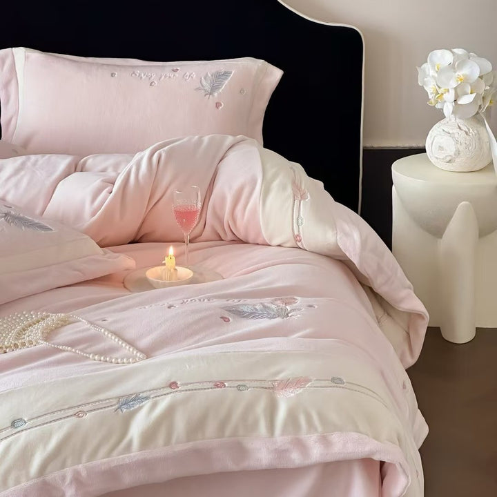Luxurious bedding set with embroidered feather motifs and quilted bedspread