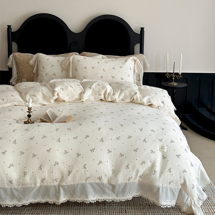 Cotton muslin bedding set with ruffles, lace trim, and delicate bow print