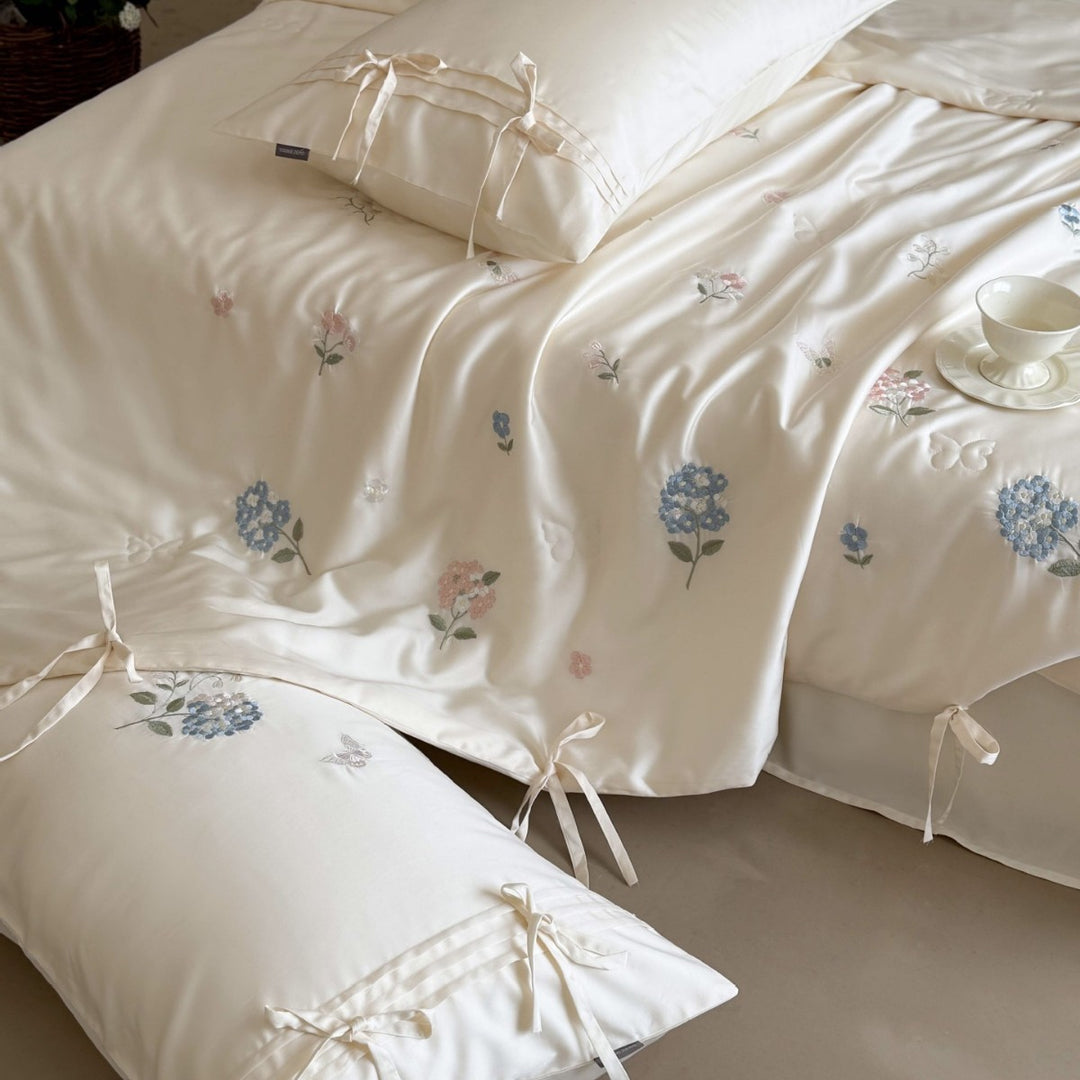 Satin bedding set with floral embroidery, tie ribbons, and silky glossy finish