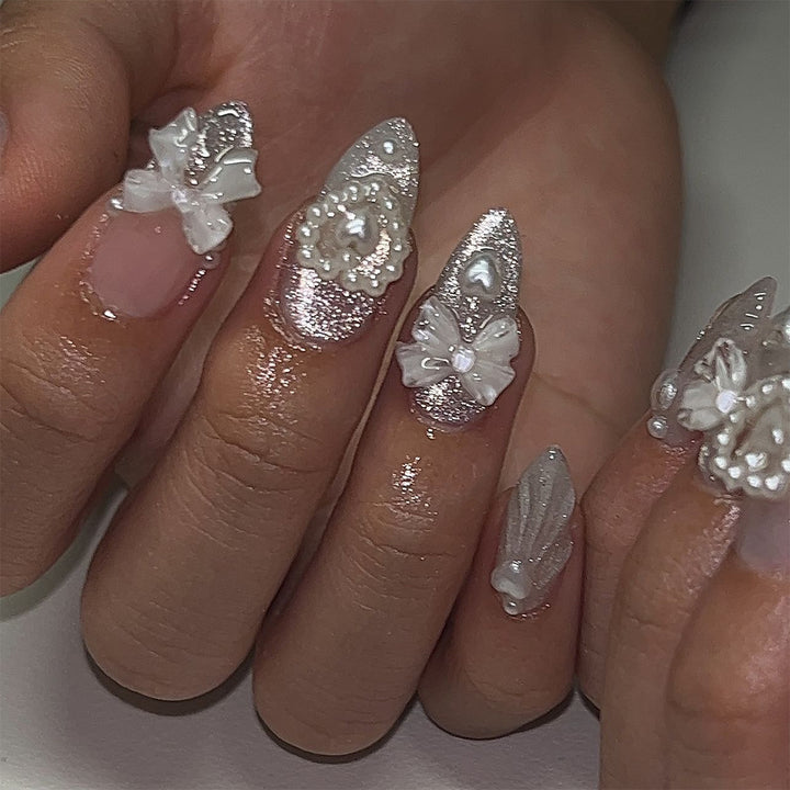 Artful nail decoration with pearl and bow accents Kalsten