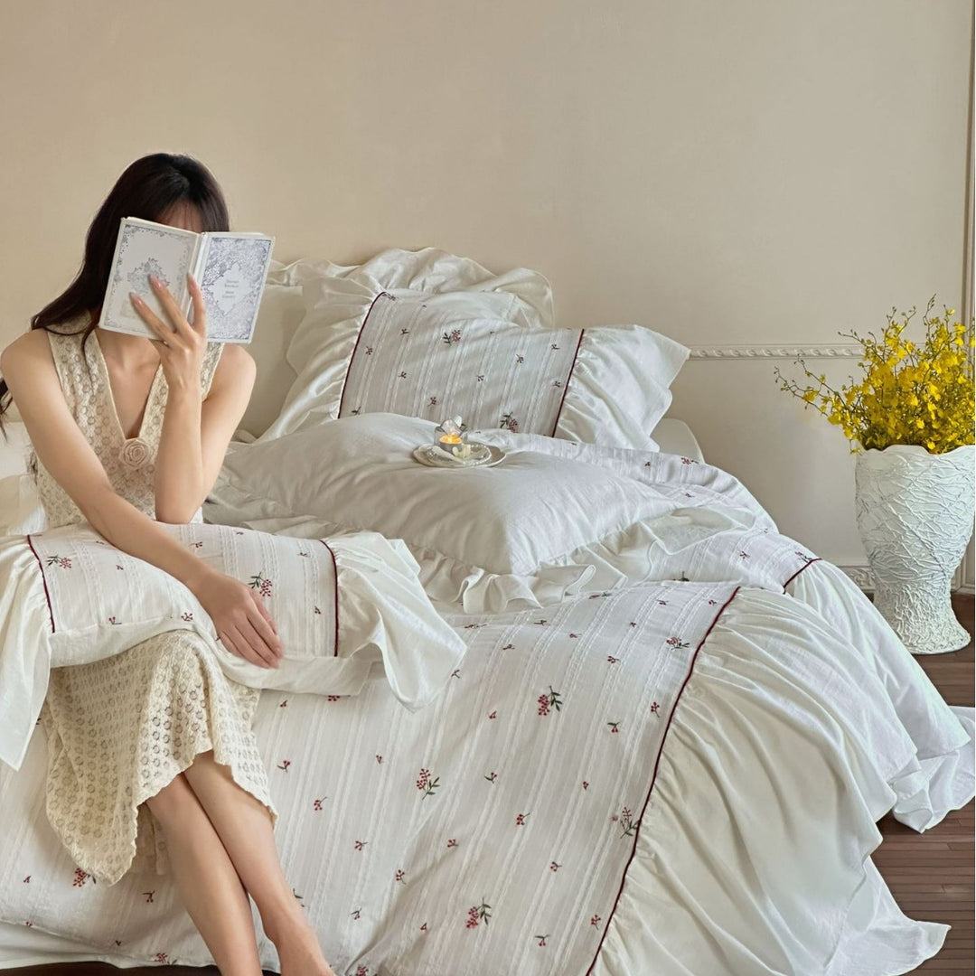 Romantic bed linen set made of cotton satin with ruffles, relief stripes, and contrasting piping