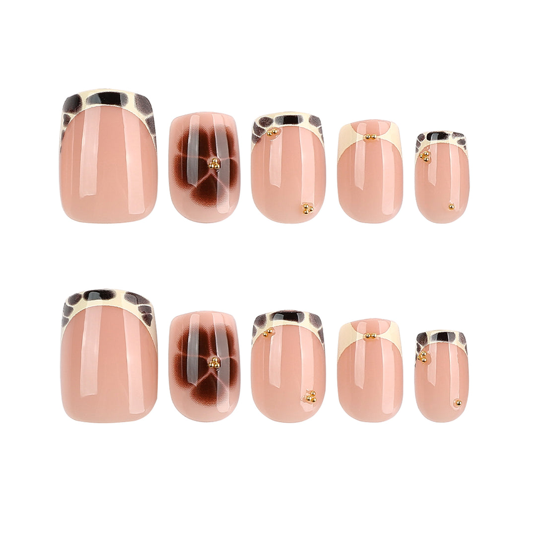 Artful nail extensions with an elegant giraffe pattern and golden accents Kalsten